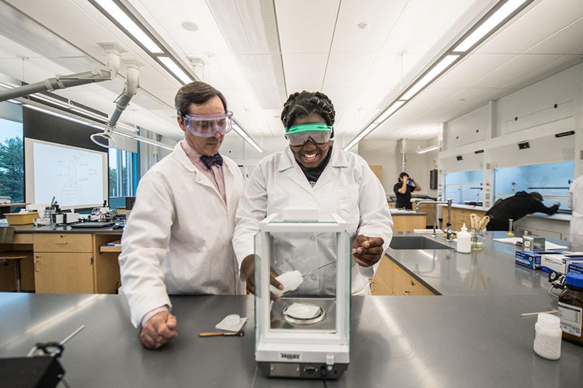 Multiple students and their professor work in a laboratory.