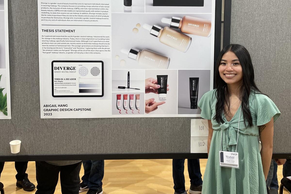 Graphic Design student smiling in front of CURCA presentation for undergraduate research.