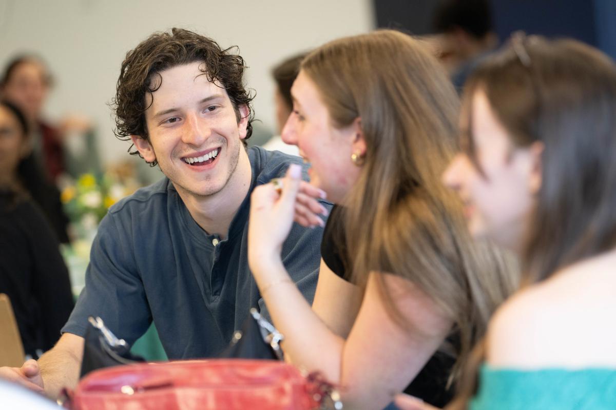 Student smiling talking with another student.
