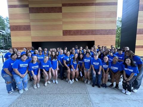 A photo of the Honors Program Students during their two-day orientation. They're standing together beside University Hall in blue shirts.