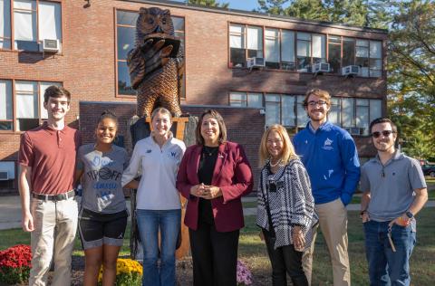 Group stands in front of Owl statue