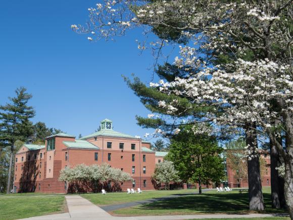 Trees in bloom on the campus green with Courtney Hall in the background