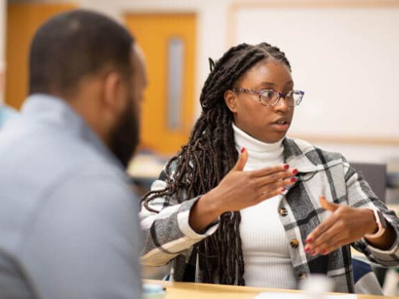 female talking to other students in class