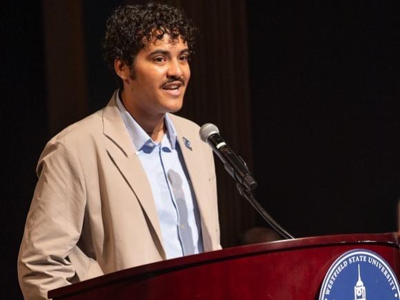 Psychology student speaking at a podium.