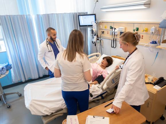 Three students engaged in an activity in the Simulation Lab.