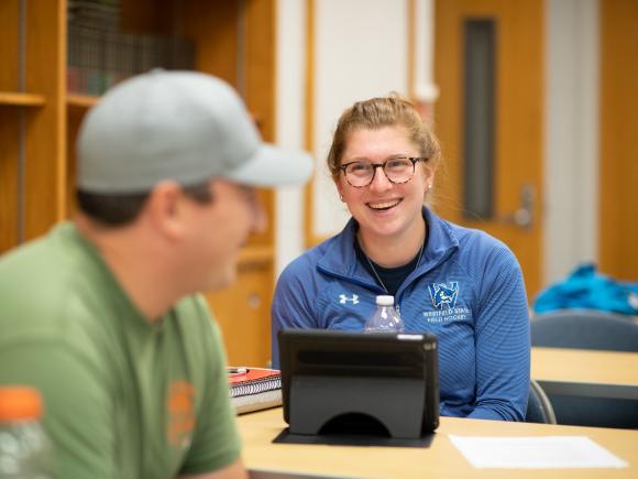 MPA student smiling and engaging in conversation with a classmate.