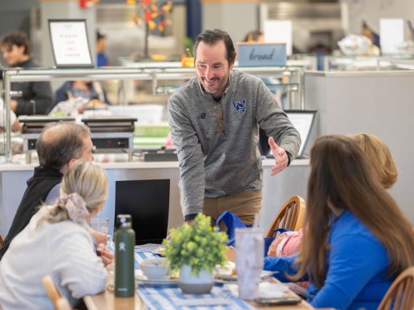 alumni talk with staff at homecoming