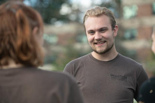 A Westfield State student in conversation with another student