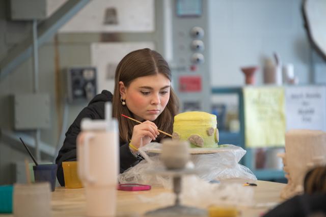 Student in Dower Center working on a ceramics project.