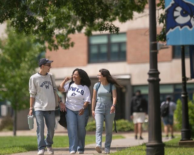 Three students walking on campus together.