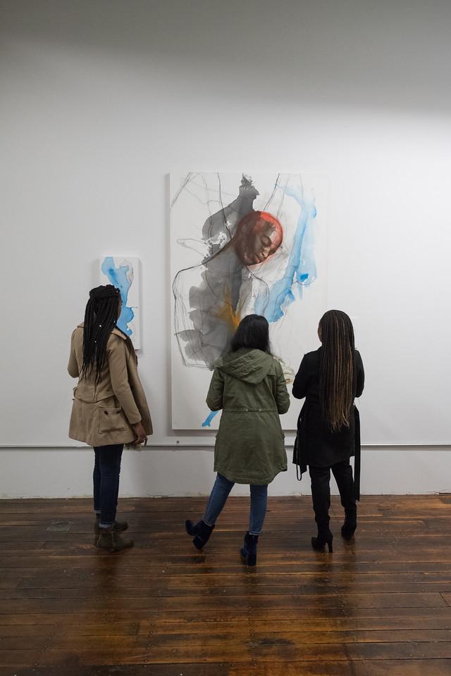 Three students viewing a painting in the Arno Maris Gallery.