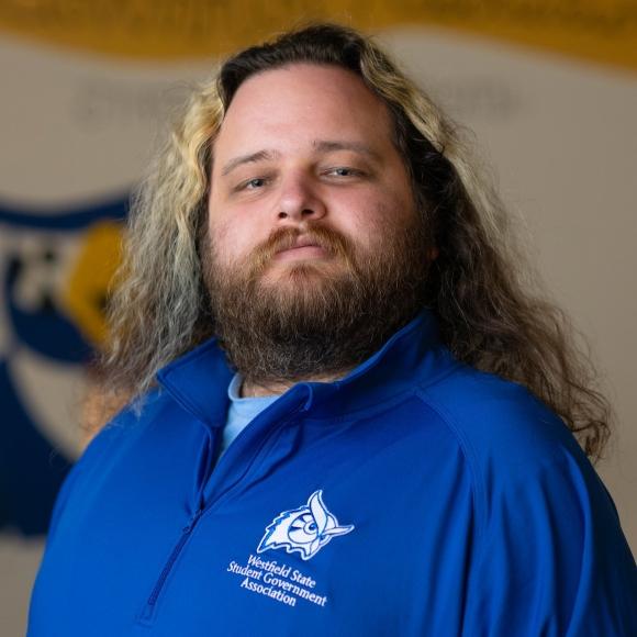 SGA Vice President of Finance Ezekiel smiling wearing a blue shirt.