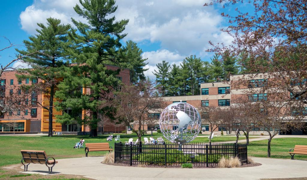 Campus globe in the summer with blue skies behind it.