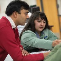 A professor works with students during a classroom activity.