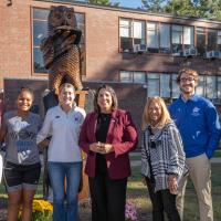 Group stands in front of Owl statue